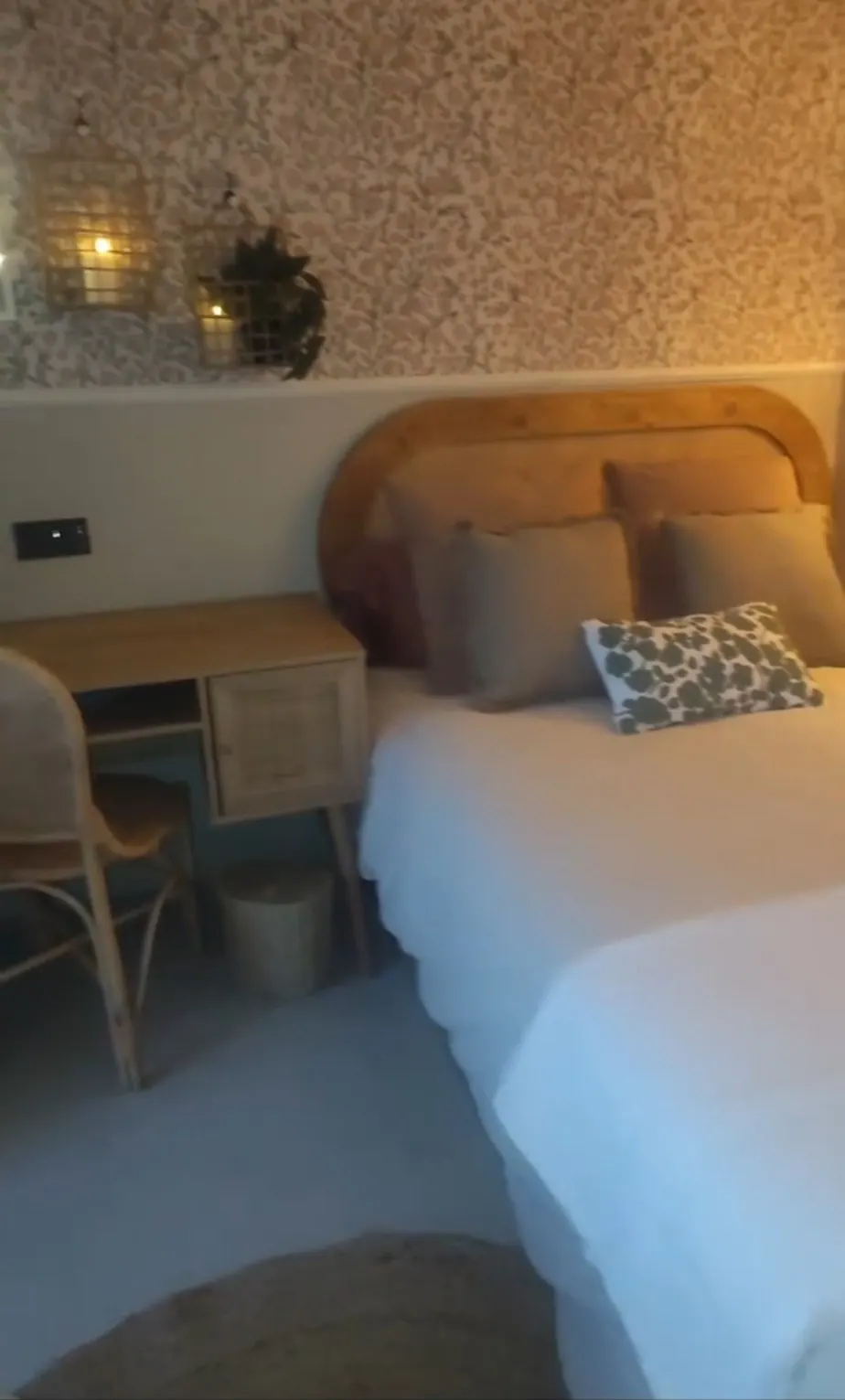 Dormitorio juvenil con papel floral, cabecero de ratán y escritorio de madera