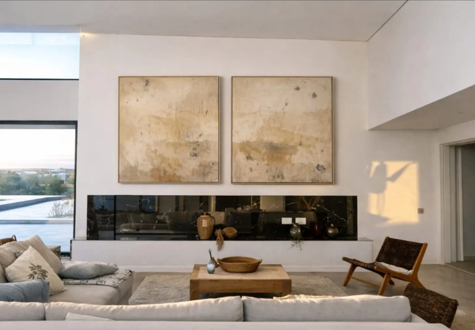 Salón con dos cuadros abstractos sobre chimenea y mesa de centro de madera maciza